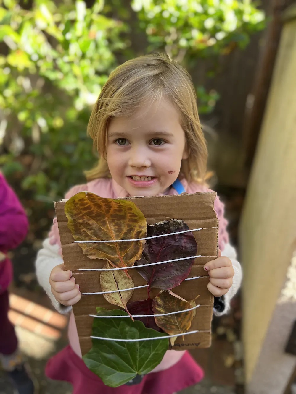 Child with leaf art at The Ross Preschool